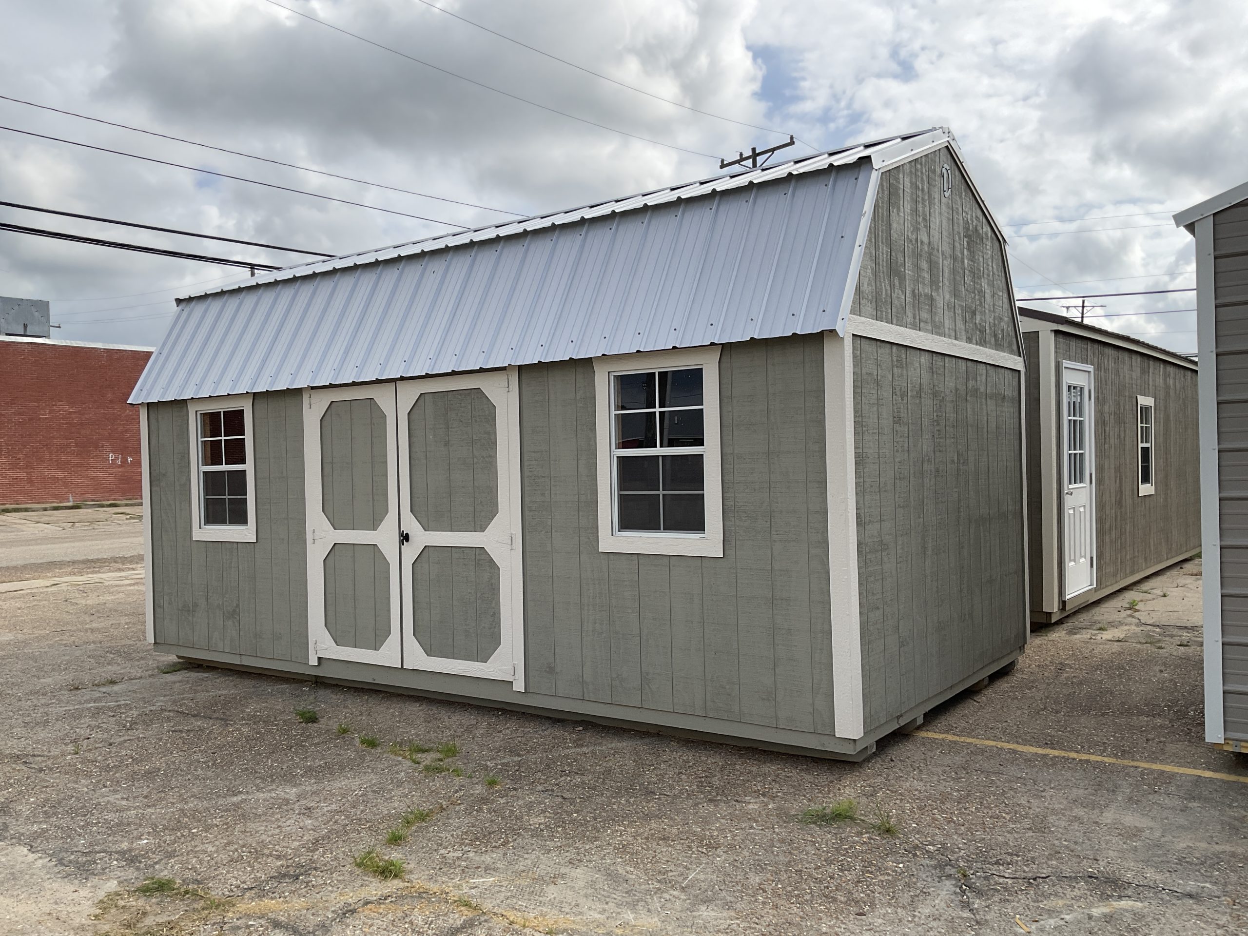 Side view of portable barn shed with windows and metal roof