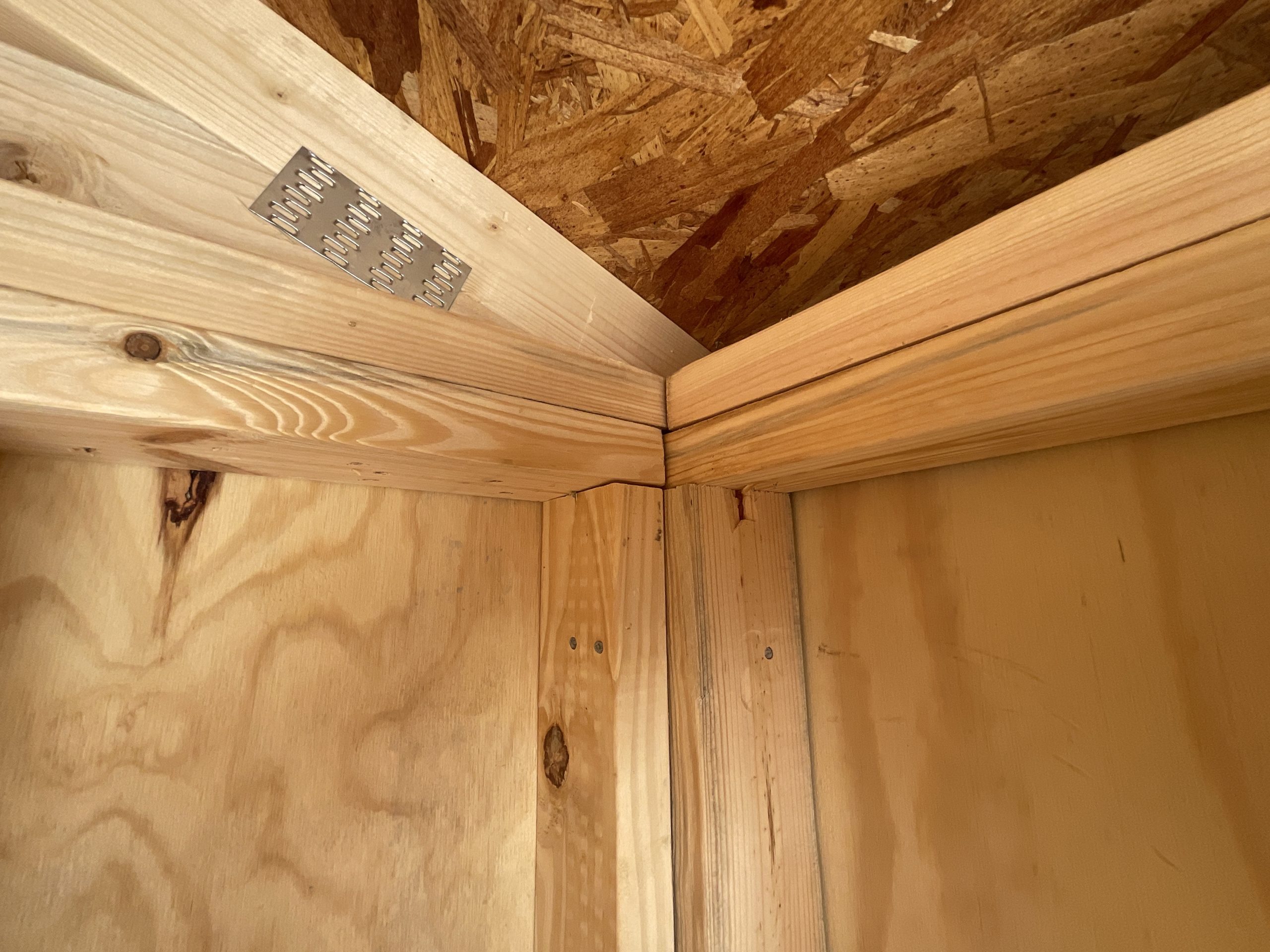 Corner framing connection inside wooden shed structure