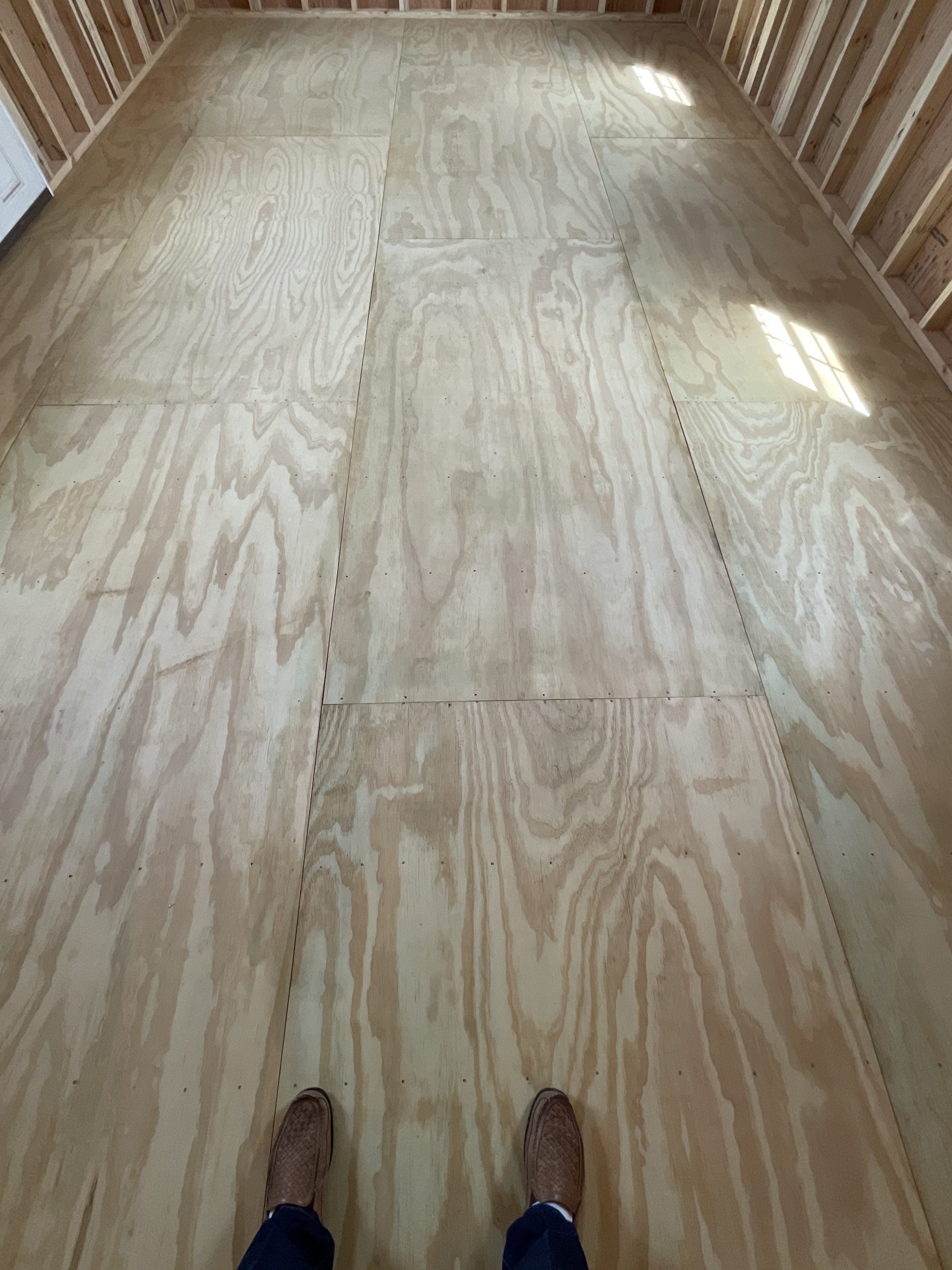 Real wood treated tongue and groove flooring inside lofted barn house shell Hammond LA