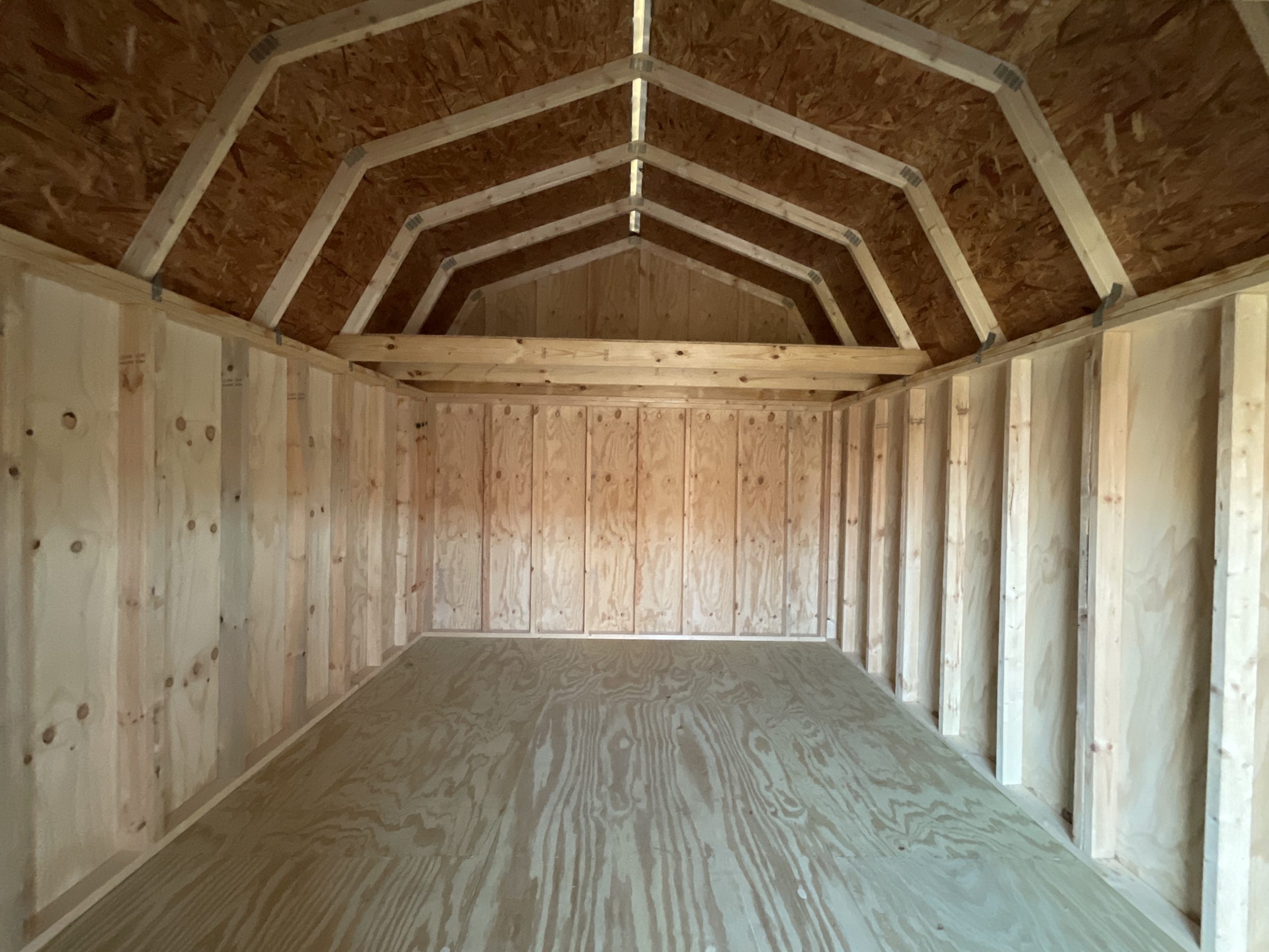 Interior of 12x16 lofted barn showing rear loft storage rafters and ridge cap vent system