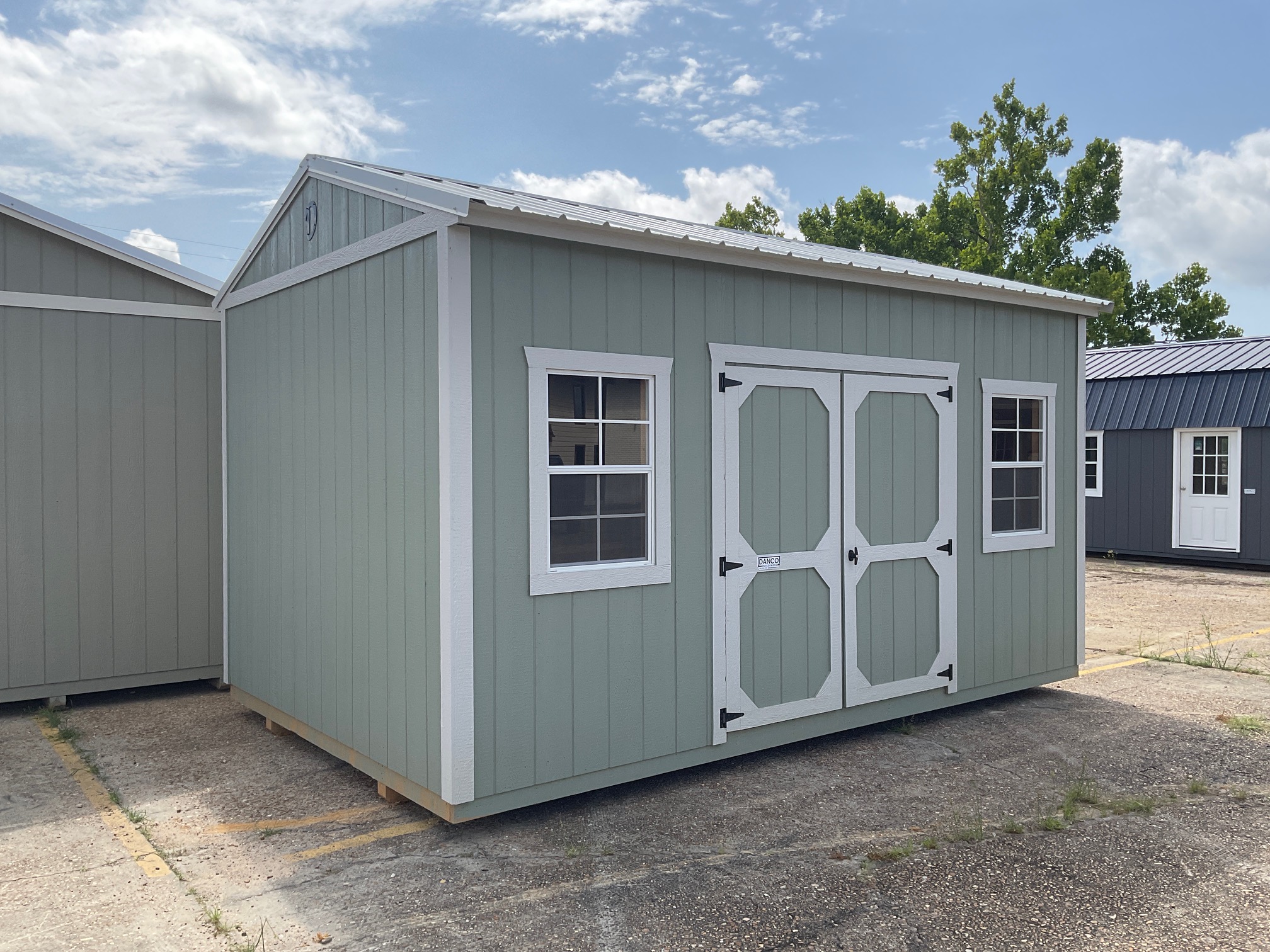 Front left view of a premium 10x16 portable garden shed with engineered wood siding and metal roof.