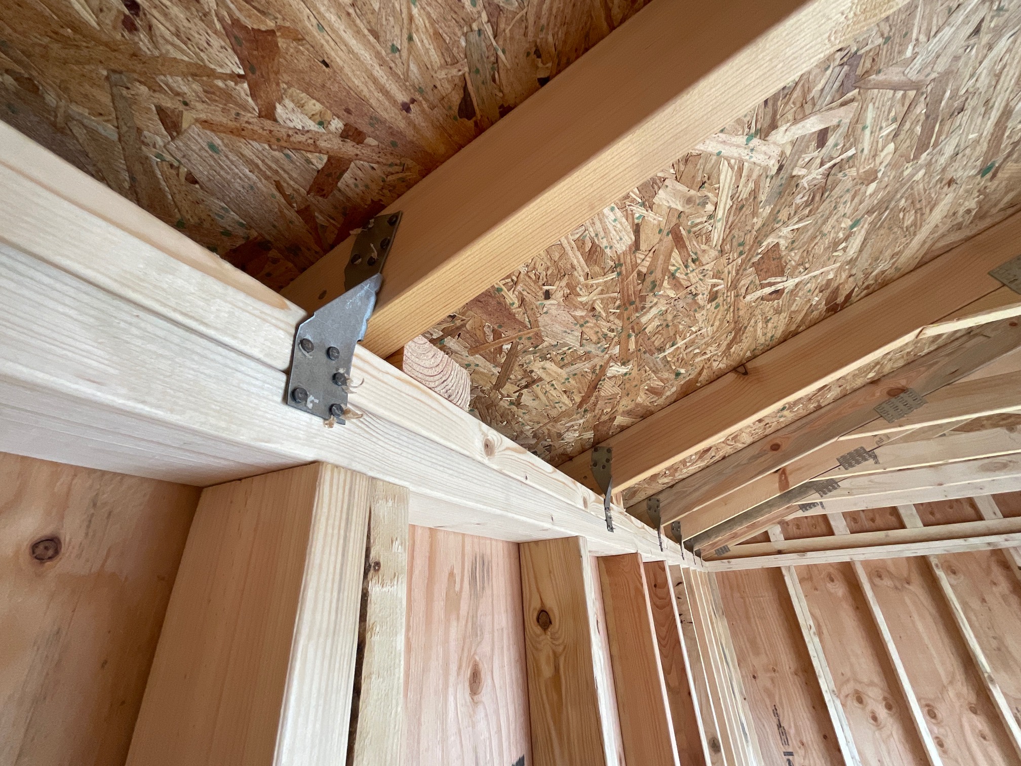 Steel hurricane clips securing the roof trusses to the wall system.