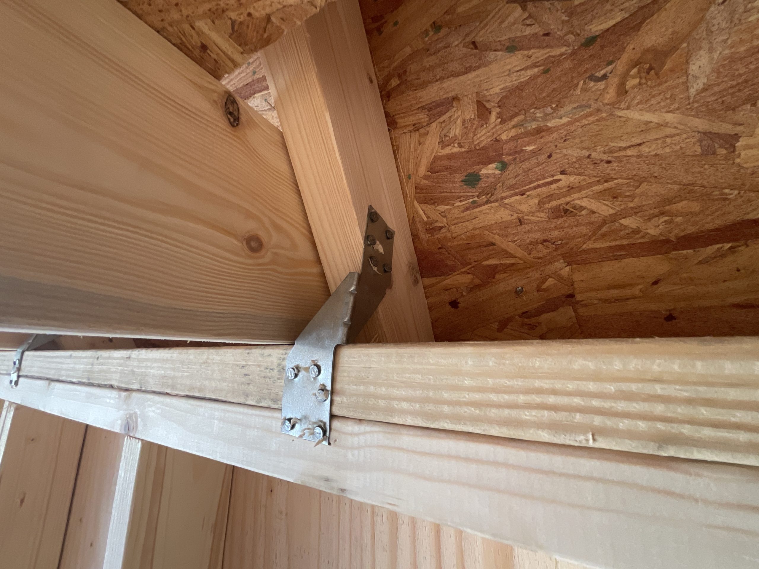 Hurricane clip connecting roof truss to wall of Lofted Barn storage shed