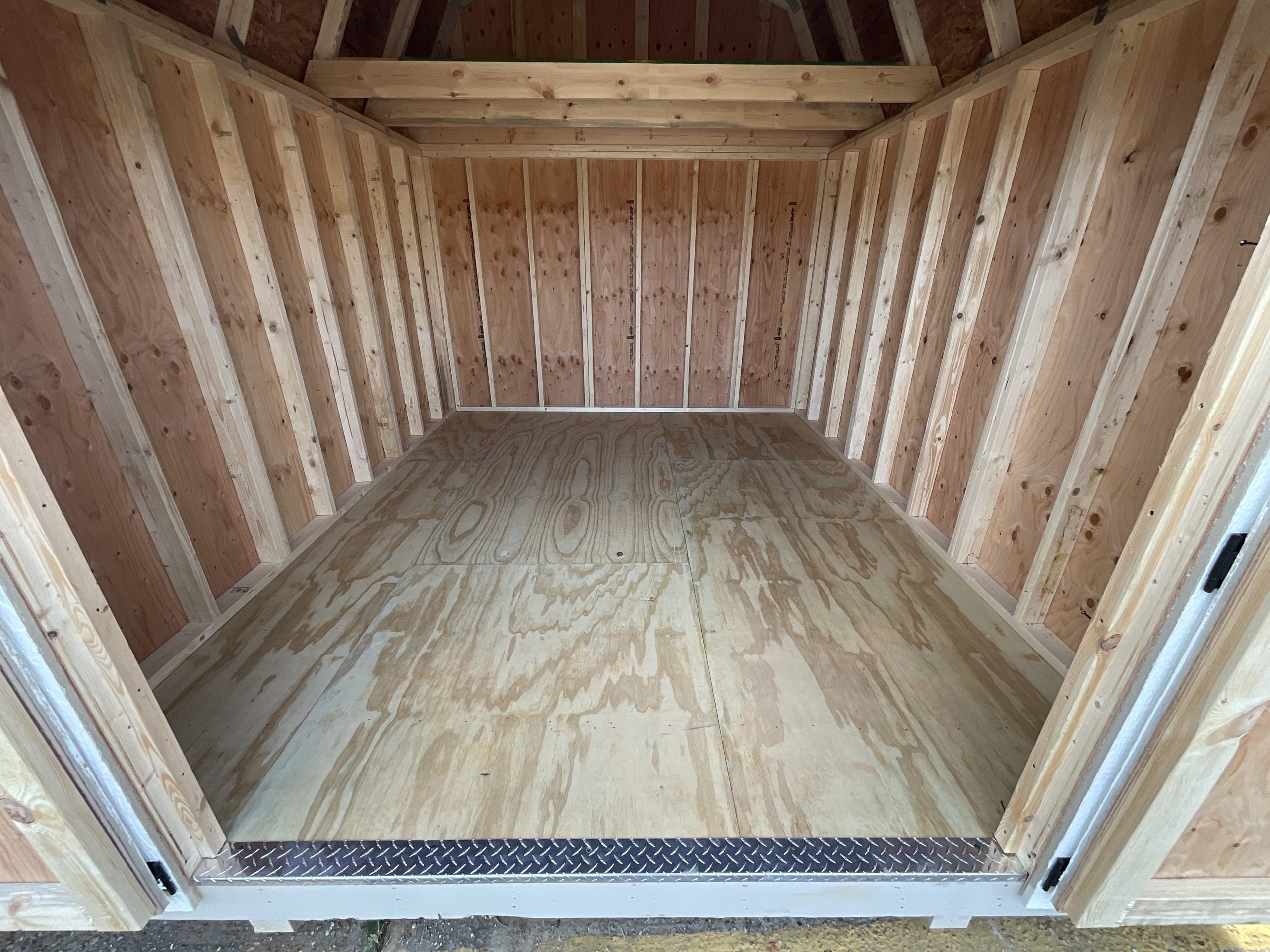 Interior of 10x12 Lofted Barn showing real wood floor and DuraTemp real wood siding