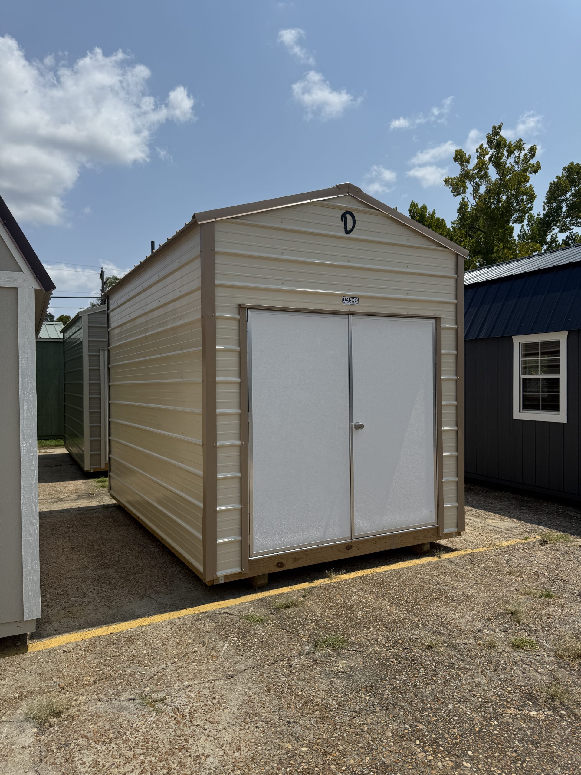 Left front view of 8x12 Ivory metal storage shed with Tan trim in Hammond LA